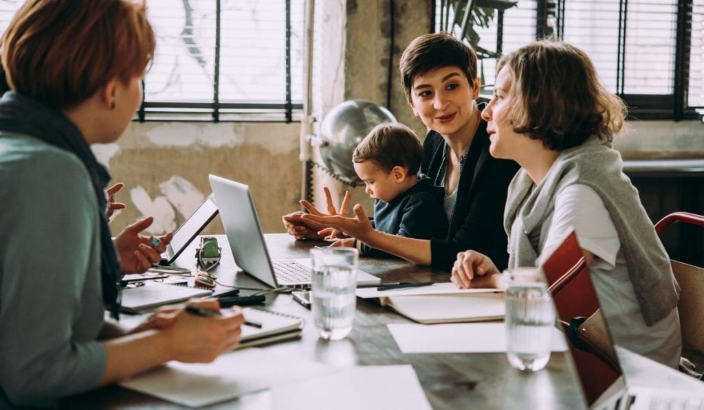 group of people sat around the table using internet